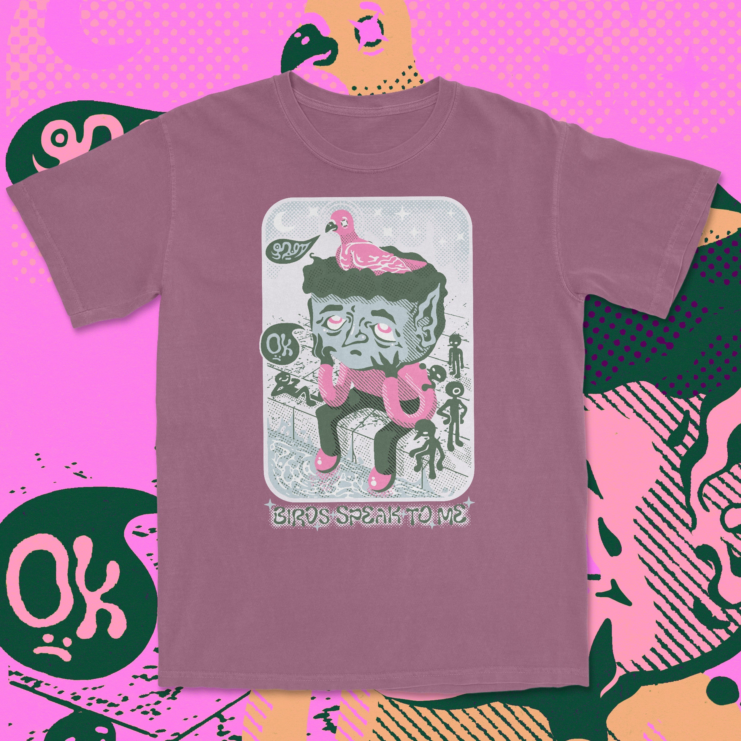 Purple t-shirt with a graphic design on a pink and green patterned background