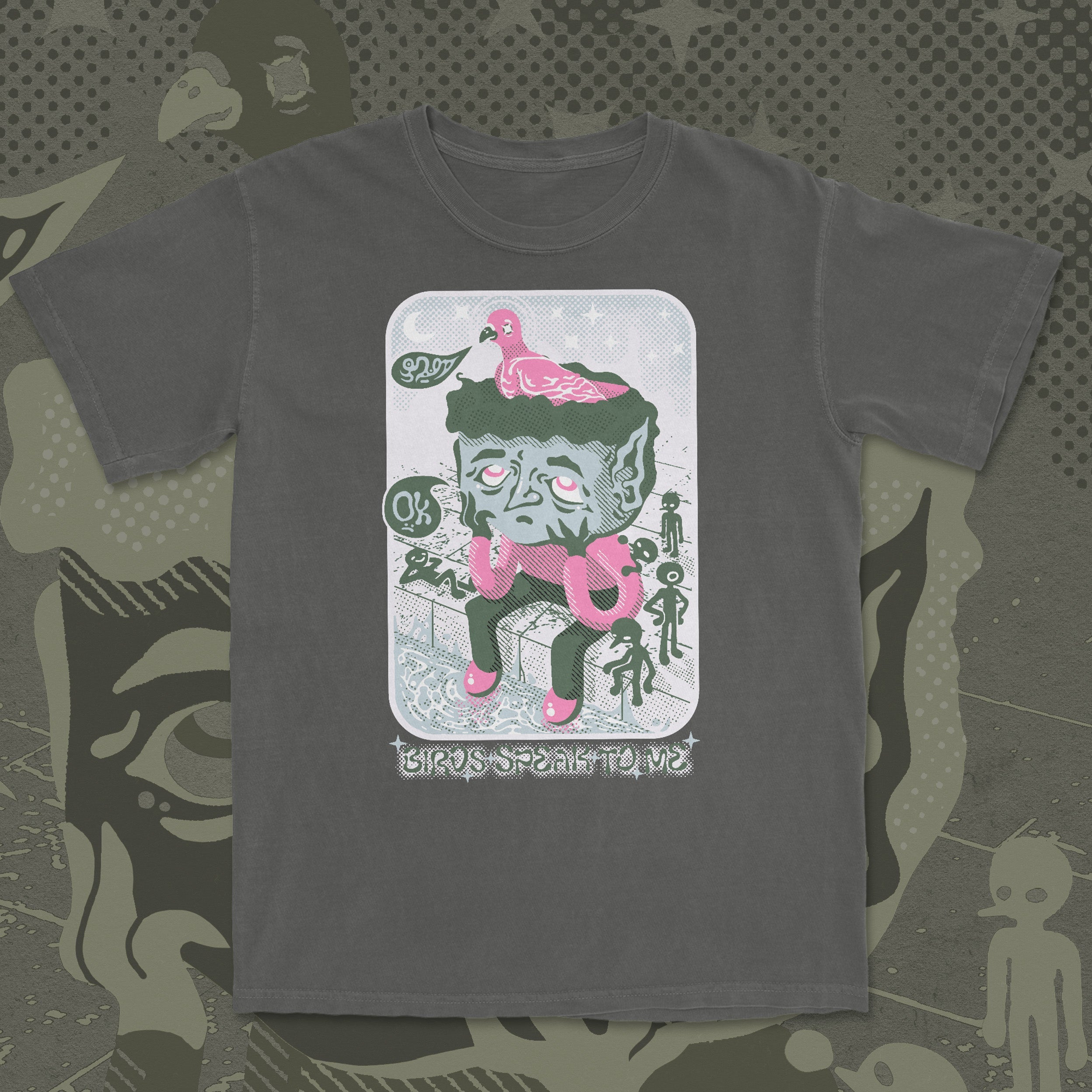 Gray t-shirt with a graphic design of a creature and pink elements on a patterned background
