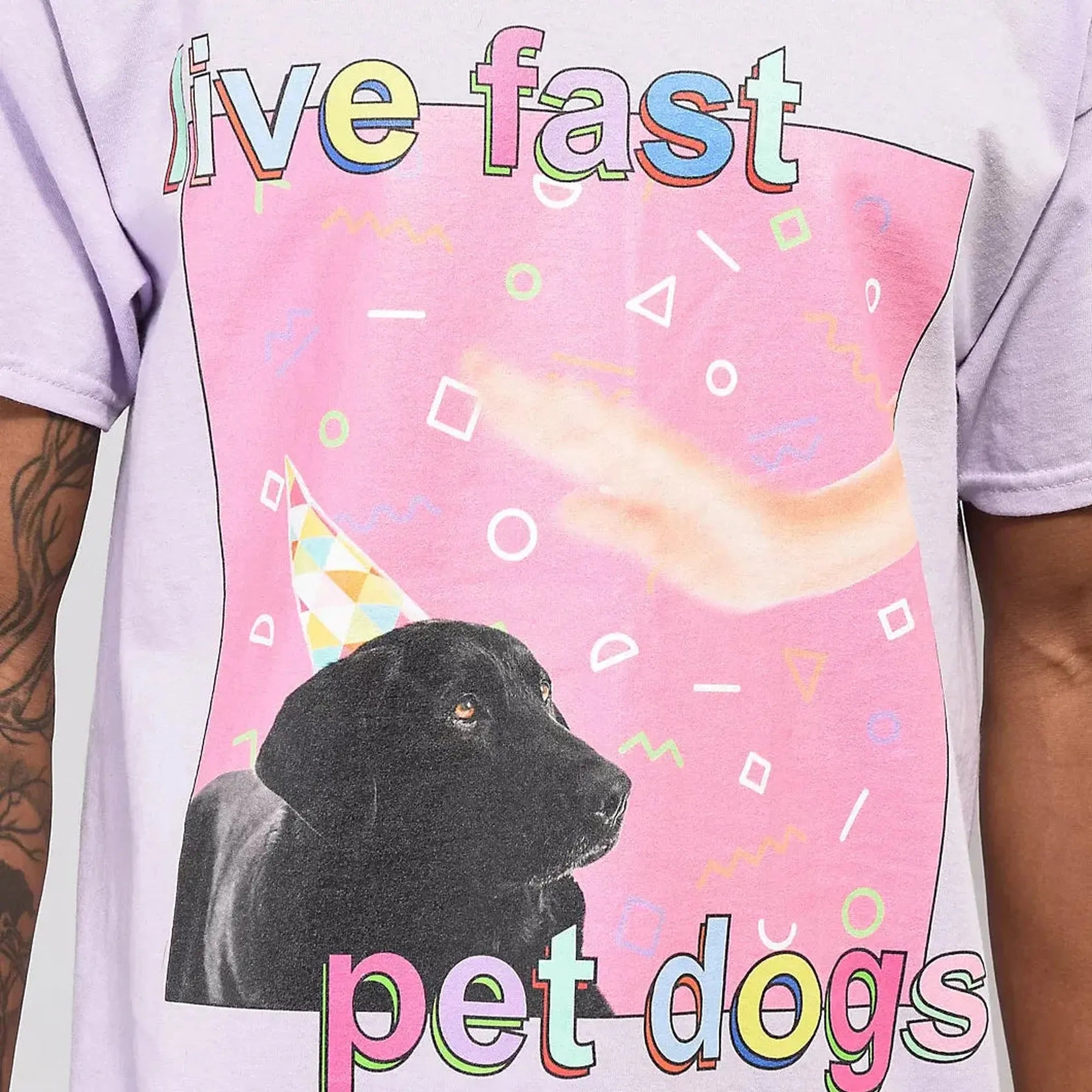 T-shirt with a black dog, colorful text, and geometric shapes on a pink background